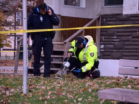 A pair of investigators preen through the grass at the scene of a shooting on Friday, Oct. 16 2015 on the corner of Montreal Rd. and Cantin St. in Vanier. /SAM COOLEY OTTAWA SUN