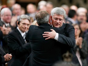 Prime Minister Stephen Harper hugs Opposition Leader Thomas Mulcair in the House of Commons in Ottawa October 23, 2014, as the government went back to work following a shooting incident October 22, in which a gunman killed a soldier and ran through Parliament shooting before being shot dead himself.  REUTERS/Chris Wattie (CANADA  - Tags: POLITICS CRIME LAW)