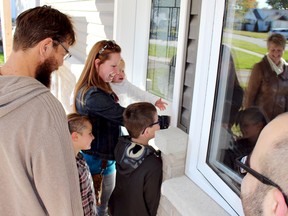 The Davis family is about to set foot inside their new home thanks to Habitat for Humanity Chatham-Kent. Ryan, left, April, Becca holding Olive and Isaac received the key to become homeowners for their very first time during an official opening ceremony in Wallaceburg, Ont. on Saturday October 17, 2015. Vicki Gough/Chatham Daily News/Postmedia Network