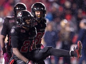 Ottawa RedBlacks' running back William Powell, second left, celebrates his touchdown against the Winnipeg Blue Bombers as teammate Greg Ellingson, right, looks on during second half CFL action in Ottawa, on Friday, Oct. 16, 2015. THE CANADIAN PRESS/Adrian Wyld