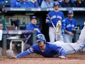 Toronto Blue Jays' Josh Donaldson slides into home plate to score on an RBI single by Edwin Encarnacion during the sixth inning in Game 2 of baseball's American League Championship Series against the Kansas City Royals on Saturday, Oct. 17, 2015, in Kansas City, Mo.  (AP Photo/Charlie Riedel)
