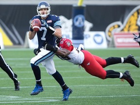 Toronto Argonauts' quarterback Trevor Harris is tackled by Calgary Stampeders' defensive lineman Freddie Bishop III, right, during the first-half of CFL football action in Hamilton, Ont., on Saturday, Oct. 17, 2015. (THE CANADIAN PRESS/Peter Power)