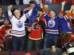 Edmonton Oilers fans celebrate in the stands after the Oilers defeated the Flames in NHL hockey action at the Scotiabank Saddledome in Calgary, Alta. on Saturday October 17, 2015. The Oilers beat the Flames 5-2. Mike Drew/Calgary Sun/Postmedia Network
