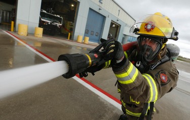 James Bates - of the Toronto Pearson Combat Team - fires off a hoseline as part of the training as they are part  are off to the Scott Firefighter Combat World Challenge in Montgomery, Alabama this Monday. Friday October 16, 2015. Jack Boland/Toronto Sun/Postmedia Network