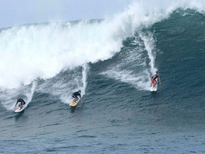 Three surfers catch a large wave at the surf spot on the outer reefs known as 'Himalayas' on the North Shore of Oahu in Haleiwa, Hawaii. REUTERS/Hugh Gentry/Files