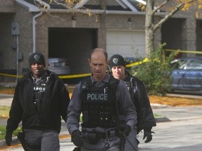 Peel Regional Police scour a Brampton neighbourhood Saturday, Oct. 17, 2015 following the shooting of a fellow officer and a civilian late Friday. (CHRIS DOUCETTE/TORONTO SUN)