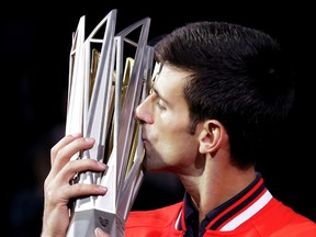 Novak Djokovic of Serbia kisses his winner's trophy after defeating Jo-Wilfried Tsonga of France in the final match of the Shanghai Masters tennis tournament at Qizhong Forest Sports City Tennis Center in Shanghai on Oct. 18, 2015. (AP Photo/Andy Wong)