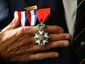Second World War veteran Norm Field, 90, displays his medal, The National Order of the Legion of Honour, on Friday July 17, 2015 at his home in Peterborough, Ont. Clifford Skarstedt/Postmedia Network