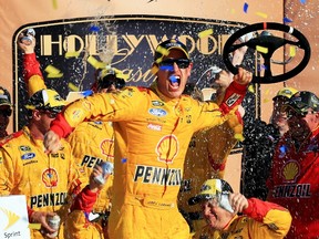 Joey Logano, driver of the #22 Shell Pennzoil Ford, celebrates in Victory Lane after winning the NASCAR Sprint Cup Series Hollywood Casino 400 at Kansas Speedway in Kansas City on Oct. 18, 2015. (Daniel Shirey/Getty Images/AFP)