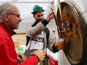 Recreating a German tradition, Mayor Taso Christopher waits for the Belleville Shrine Oktoberfest's first glass of beer from master brewer Dan O'Brien Saturday. The tradition requires the mayor to taste the beer, reward the brewmaster with gold if he likes the beer, and begin the festival.