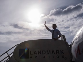 Liberal Leader Justin Trudeau waves as he boards his plane en route for Vancouver,  Sunday, October 18, 2015 in Calgary. THE CANADIAN PRESS/Paul Chiasson