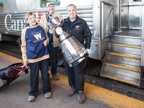 Marge Avent, Ted Avent and Dennis Dowell, a Grey Cup Handler, board a VIA Rail train to tour with the cup Sunday. (Matt Duboff Photography)