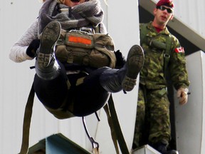 Christine Petherick of Campbellford, Ont. gets into the swing of parachuting while at CFB Trenton, Ont. Saturday, Oct. 17, 2015. Base staff let civilians try their mock parachute tower and rappel tower in exchange for donations to the United Way of Quinte.