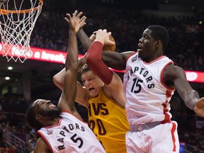 Cleveland Cavaliers' Timofey Mozgov, centre, is fouled by Toronto Raptors' DeMarre Carroll, left, as Raptors Anthony Bennett defends during first half NBA pre-season basketball action in Toronto on Oct. 18, 2015. (THE CANADIAN PRESS/Chris Young)