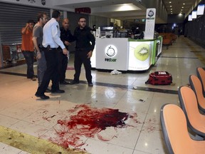 Israeli security stand next to blood on the floor, at the Beersheba central bus station where a Palestinian gunman went on a stabbing and shooting rampage, October 18, 2015. The rampage took place at the central bus station in the southern Israeli city of Beersheba on Sunday, killing one person and wounding several, police said, in one of the most serious recent events of Palestinian-Israeli violence. Initial reports said two attackers were involved but the regional police commander said investigators later believed there was only one. Police commander Yoram Halevy said the attacker, whose identity was being checked, had entered the secured bus station and used a handgun to attack and kill a soldier and grab his assault rifle, which he later used to shoot at others. REUTERS/Dudu Grunshpan