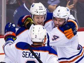 Edmonton Oilers' Lauri Korpikowski (28) celebrates his game winning goal against the Vancouver Canucks with teammates Andrej Sekera (2) and Taylor Hall (4) during overtime of their NHL hockey game in Vancouver, B.C., on Sunday October 18, 2015. THE CANADIAN PRESS/Ben Nelms