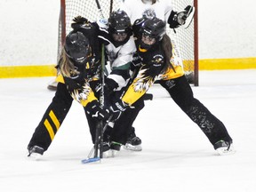 Hannah Redfern (left) and Jaci Mitchell of the Mitchell U14AA ringette team double teams this London opponent for possession of the ring during WORL league action last Tuesday, Oct. 13. Mitchell won, 5-0. ANDY BADER/MITCHELL ADVOCATE
