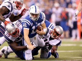 Andrew Luck #12 of the Indianapolis Colts is sacked by Chandler Jones #95 and Dominique Easley #99 of the New England Patriots at Lucas Oil Stadium on October 18, 2015 in Indianapolis, Indiana.   Andy Lyons/Getty Images/AFP