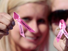 Members of Zeta Tau Alpha hold pink ribbons that were handed out to fans before an NFL football game between the Green Bay Packers and the Denver Broncos, Sunday, Oct. 2, 2011, in Green Bay, Wis. Nearly 25 years since the red ribbon became the global symbol of AIDS awareness, countless other organizations have followed the rainbow in highlighting their causes through colour. (THE CANADIAN PRESS/AP/Mike Roemer)