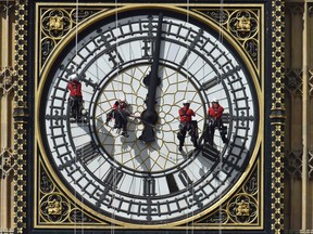 Cleaners abseil down one of the faces of Big Ben, to clean and polish the clock face, above the Houses of Parliament, in central London in this file picture taken August 19, 2014. REUTERS/Toby Melville