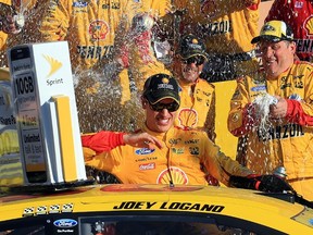 Joey Logano, driver of the #22 Shell Pennzoil Ford, celebrates in Victory Lane after winning the NASCAR Sprint Cup Series Hollywood Casino 400 at Kansas Speedway on October 18, 2015 in Kansas City, Kansas.   Daniel Shirey/Getty Images/AFP