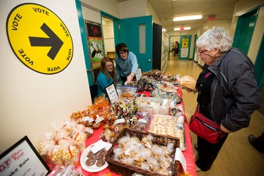 Voters check out the Clara Tyner Elementary School, 9420 Ottewell Rd., bake sale fundraiser outside the Federal Election polling station in the school, in Edmonton Alta. on Monday Oct. 19, 2015. The bake sale was held in the hallway just outside the school gym where the polling station was set up. David Bloom/Edmonton Sun/Postmedia Network