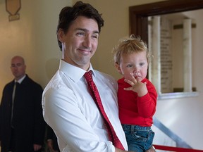 Liberal leader Justin Trudeau carries his son Hadrien as he enters the polling station to cast his vote Monday, Oct. 19, 2015 in Montreal. THE CANADIAN PRESS/Paul Chiasson