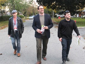 Kingston and the Islands Liberal candidate Mark Gerretsen, centre, is flanked by campaign volunteers David McQuaide, left, and Zach MacInnis as they walk down Casterton Avenue in Kingston, Ont. on Monday, Oct. 19, 2015 while canvassing door-to-door. Michael Lea/The Whig-Standard/Postmedia Network