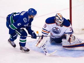 Oilers goaltender Anders Nilsson stops Canucks forward Sven Baertschi during Sunday's game in Vancouver. (The Canadian Press)