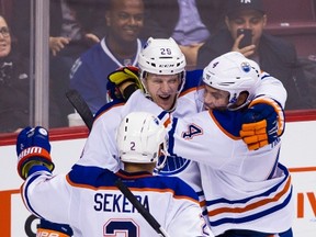 Lauri Korpikoski celebrates his overtime goal with teammates Andrej Sekera, left, and Taylor Hall after Sunday's game in Vancouver. (The Canadian Press)