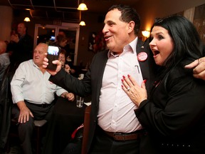 Marc Serre and his wife Lynn watch in excitement as results roll in at the Parthenon Restaurant in Sudbury, Ont. on Monday October 19, 2015. Gino Donato/Sudbury Star/Postmedia Network