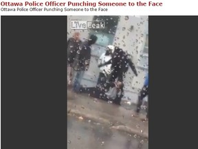 This video seems to show a police officer punching a man in the face as he lies on the ground.