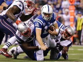 Colts quarterback Andrew Luck (12) is sacked by Patriots defensive end Chandler Jones (95) and defensive tackle Dominique Easley (99) during NFL action in Indianapolis on Sunday, Oct. 18, 2015. (AP Photo/John Minchillo)