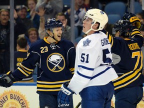 Toronto Maple Leafs' Jake Gardiner reacts as Buffalo Sabres' Sam Reinhart celebrates with Evan Rodrigues after Rodrigues scored during the third period of an NHL preseason game in Buffalo on Sept. 29, 2015. (AP Photo/Gary Wiepert)