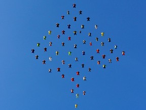 This photo taken, Oct. 17, 2015, and provided by Skydive Perris shows 61 wingsuit skydivers setting a new world record for the largest aerial formation in the sky over Perris, Calif., about 70 miles southeast of Los Angeles. Exiting from three airplanes at 13,5000 feet, flyers formed a diamond shape in flight, covering a distance of more than two miles, before dispersing at 5,500 feet. The record event included participants from 12 countries. (Mark Harris/Skydive Perris via AP)