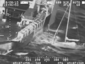 In this frame from video provided by the U.S. Coast Guard, a Frenchman with his cat tucked inside his clothing, at right, stands on his sailboat before making a leap Tuesday, Oct. 20, 2015, jumping to a waiting rescue ship, left, south of Alaska. The video shows the Frenchman on the rigging pole near the bow of his sailboat, riding wave after wave until making a dramatic leap over the railing of the Tor Viking. (Coast Guard via AP)