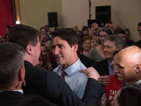 Canadian Liberal Party leader Justin Trudeau greets a supporter at the end of his speech at a victory rally in Ottawa on October 20, 2015 after winning the general elections.  Liberal leader Justin Trudeau reached out to Canada's traditional allies after winning a landslide election mandate to change tack on global warming and return to the multilateralism sometimes shunned by his predecessor.   AFP PHOTO/ NICHOLAS KAMM