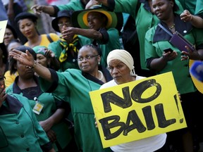 Members of the ANC Women's League (ANCWL) hold placards after a bail hearing of Danish man Peter Frederiksen was postponed at the Bloemfontein court September 28, 2015. The Danish gun store owner found with 21 pieces of female genitals stored in his home freezer has been detained and will face charges of sexual assault, intimidation and domestic violence, South African police said last Monday. (REUTERS/Siphiwe Sibeko)