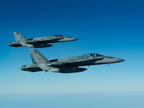 Two Royal Canadian Air Force CF-18 Hornets from Cold Lake, Alta., keep pace with the CC-150 Polaris after refueling for the next mission over Iraq during Operation IMPACT on February 4, 2015. (Canadian Forces/Combat Camera/DND)