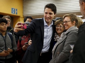 Liberal leader and prime minister-designate Justin Trudeau takes a selfie while greeting people at a subway station in Montreal, Quebec, October 20, 2015. (REUTERS/Chris Wattie)