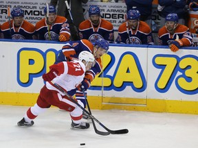 Edmonton Oilers’ Taylor Hall is checked by Detroit Red Wings’ Dylan Larkin during first-period NHL action at Rexall Place Wednesday. (Perry Mah, Edmonton Sun)