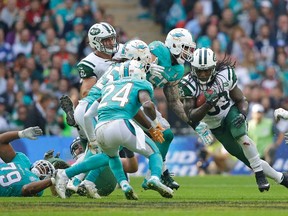 New York Jets' Chris Ivory, center, makes yardage during the NFL football game between the New York Jets and the Miami Dolphins and at Wembley stadium in London, Sunday, Oct. 4, 2015. (AP Photo/Matt Dunham)