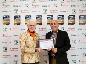 IAAF Council member Abby Hoffman presents John Halvorsen, race director for the Tamarack Ottawa Race Weekend, with the IAAF Gold label Thursday. (TIM BAINES Ottawa Sun / Postmedia Network)