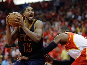 In this Friday, May 22, 2015 file photo, Cleveland Cavaliers center Tristan Thompson (13) moves past Atlanta Hawks forward Paul Millsap (4) during the second half in Game 2 of the Eastern Conference finals of the NBA basketball playoffs in Atlanta. The Cavaliers and free-agent forward Tristan Thompson have agreed in principle on a five-year, $82 million contract, ending his holdout, Wednesday, Oct. 21, 2015. (AP Photo/David Goldman, File)