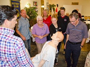 Rotarians gather around Sim Man, a high fidelity medical simulation mannequin worth $80, 0000, during a luncheon on Oct. 15, 2015.  Adding some excitement to lunch, the diners took part in an emergency scenario that involved CPR, defibrillators and paramedics. John Stoesser photo/Pincher Creek Echo