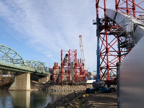 The future Walterdale bridge sits in pieces on the banks of the North Saksatchewan being readied for their eventual move, via barge, across the river so they can be hoisted into place. The old bridge will then be dismantled along with the giant red towers being used to assemble the new bridge. DAVE LAZZARINO/EDMONTON SUN