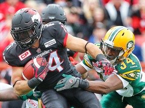 Ryan Hinds tackles Stampeders Matt Walter in the Labour Day game in Calgary. (Al Charest, Postmedia Network)