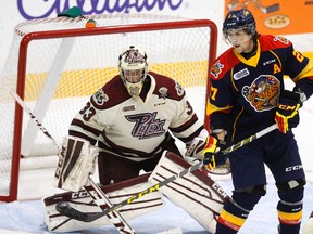 Erie Otters’ Jake Marchment deflects the puck at Petes goalie Matthew Mancina during OHL action in Peterborough on Oct. 15. (Clifford Skarstedt/Postmedia Network)