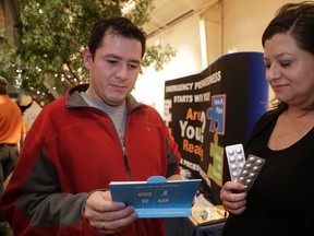 Mary Mareno and Diego Pinzon, who live within the 10 km zone of the Pickering nuclear plant, get information on the distribution of potassium iodide (KI) pills on Thursday October 22, 2015. (Craig Robertson/Toronto Sun)