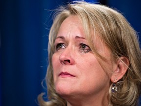 Quebec Public Security Minister Lise Theriault is in tears as she ponders reporters questions Friday, October 23, 2015 at the legislature in Quebec City. Theriault ays eight provincial police officers who allegedly sexually assaulted native women have been put on administrative leave. (THE CANADIAN PRESS/Jacques Boissinot)